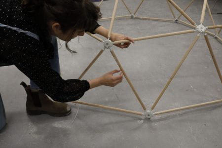 An image of a person working on a geodesic dome structure