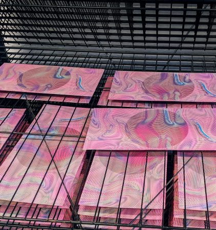 Photo of screen prints on a rack