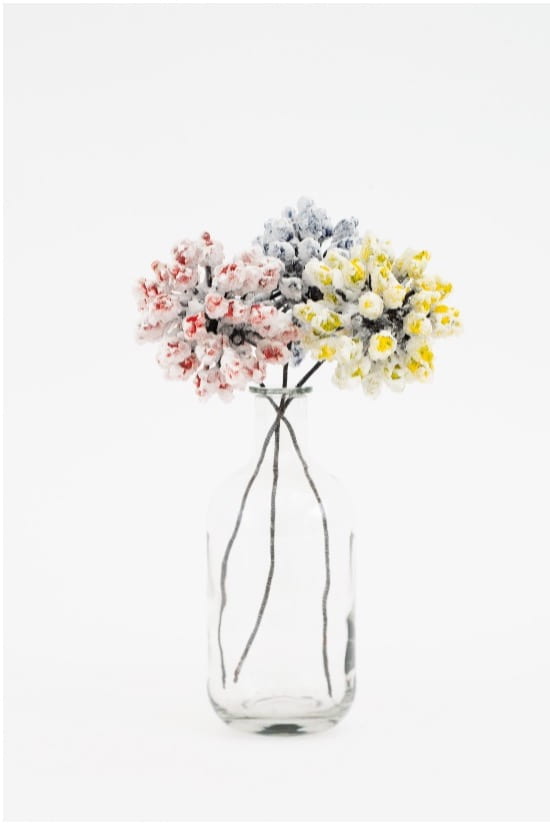 Fake flowers sit in a clear vase
