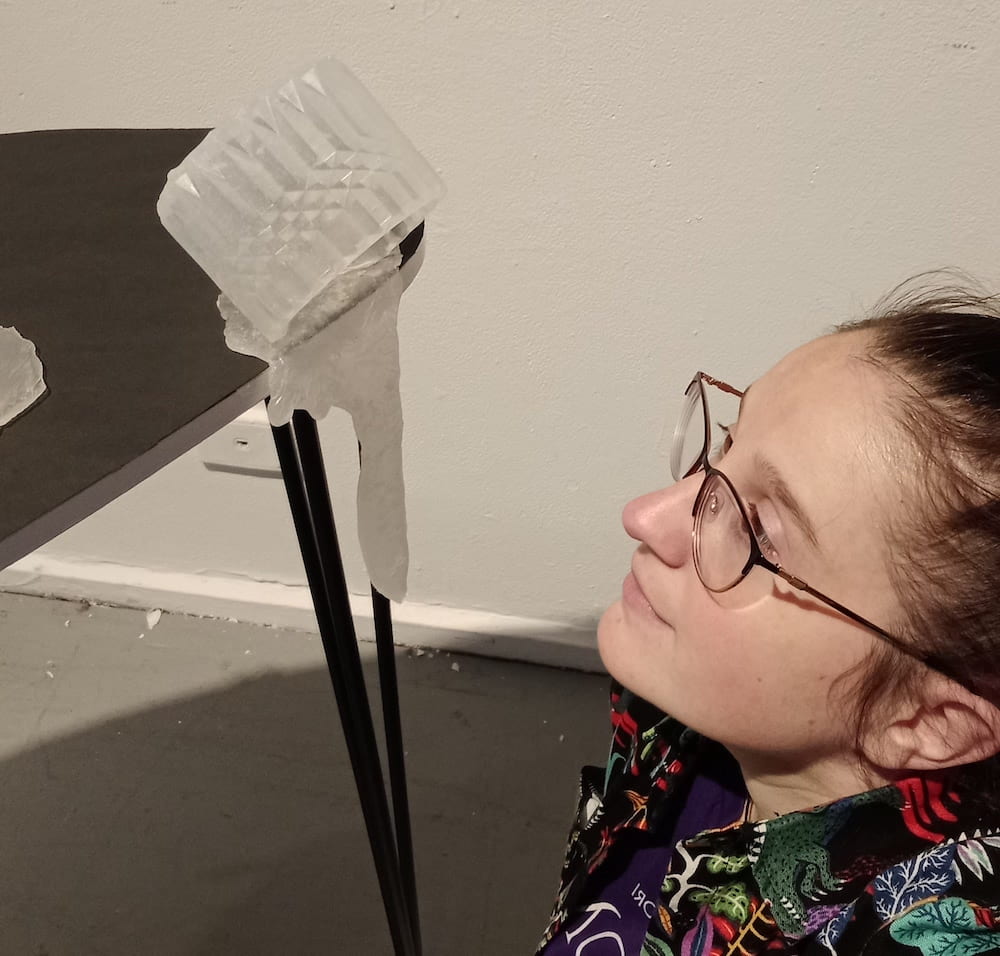Sculpture on edge of table with artist