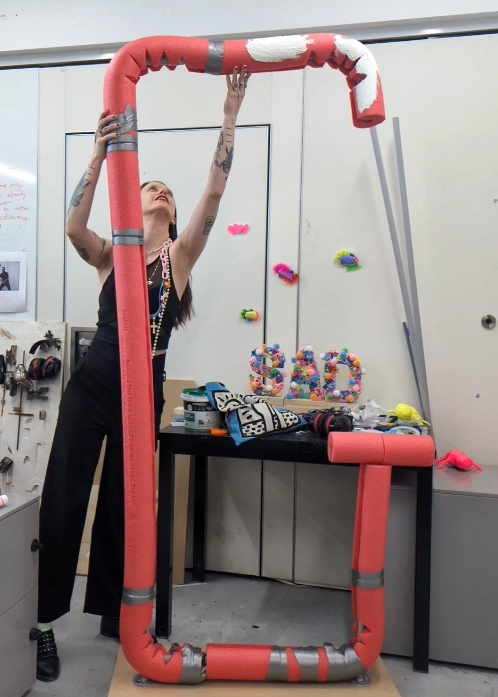 Emmica Lore is working on a sculpture of a giant G made from pool noodles.