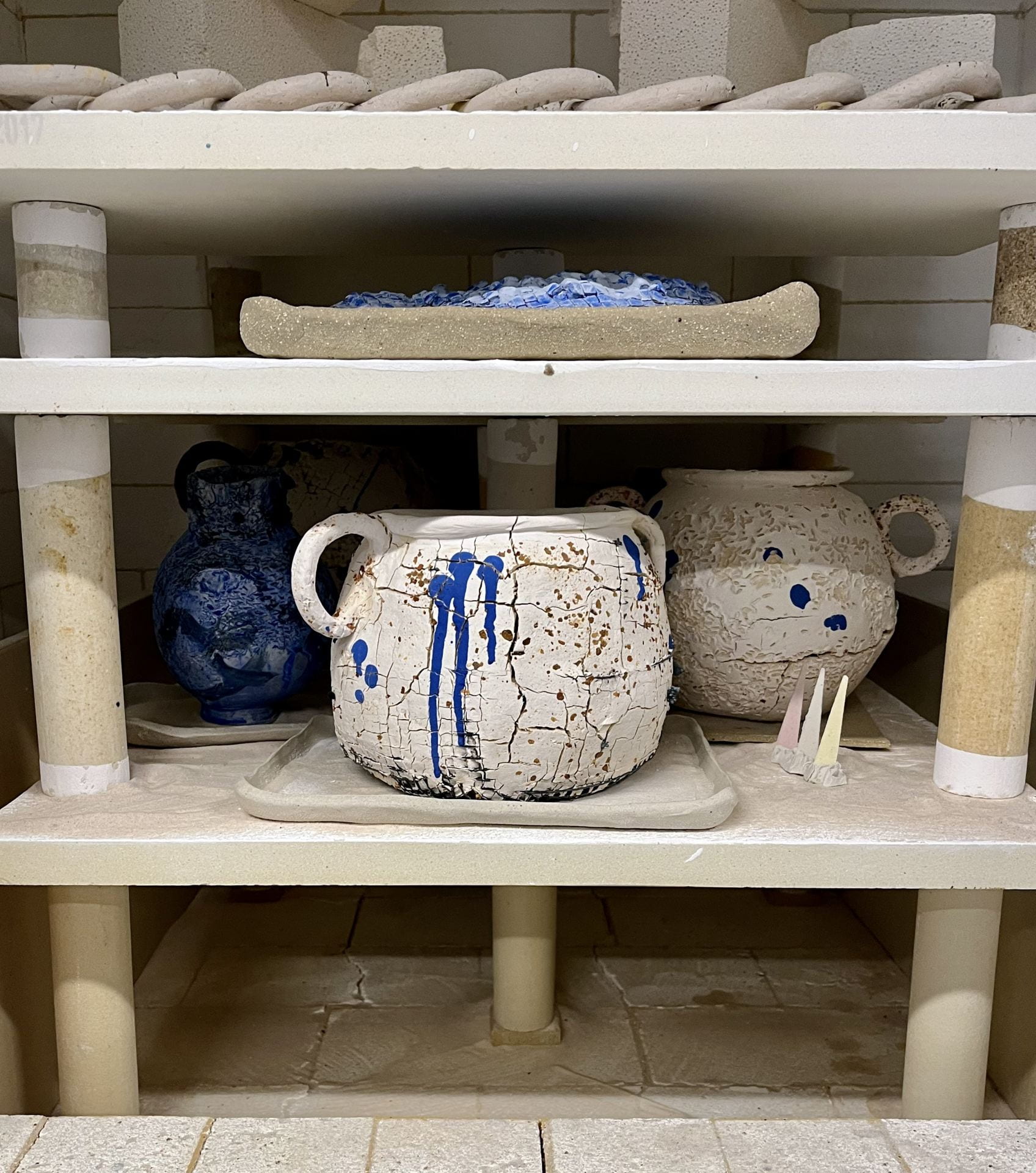 Kiln packed with moon jars, cones on the shelf, gas kiln, ready to be fired.