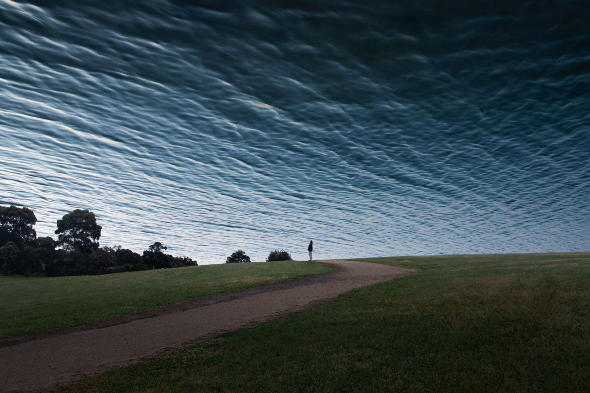 Photograph of a person looking up to the ocean in the sky