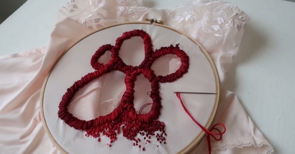 Photograph of a work in progress showing embroidery on an undergarment.