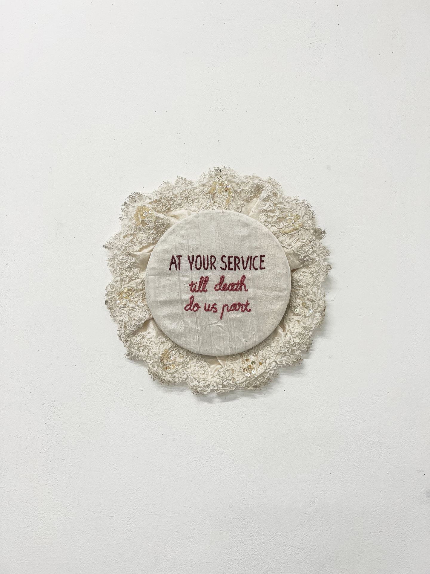 photograph of embroidery work hung on wall