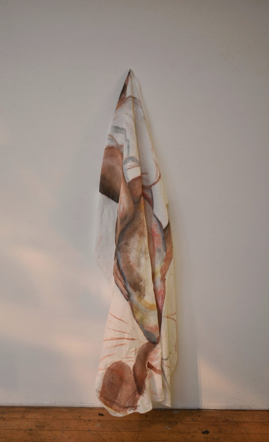 Figurative painting on a bed sheet draped on a pin on a wall