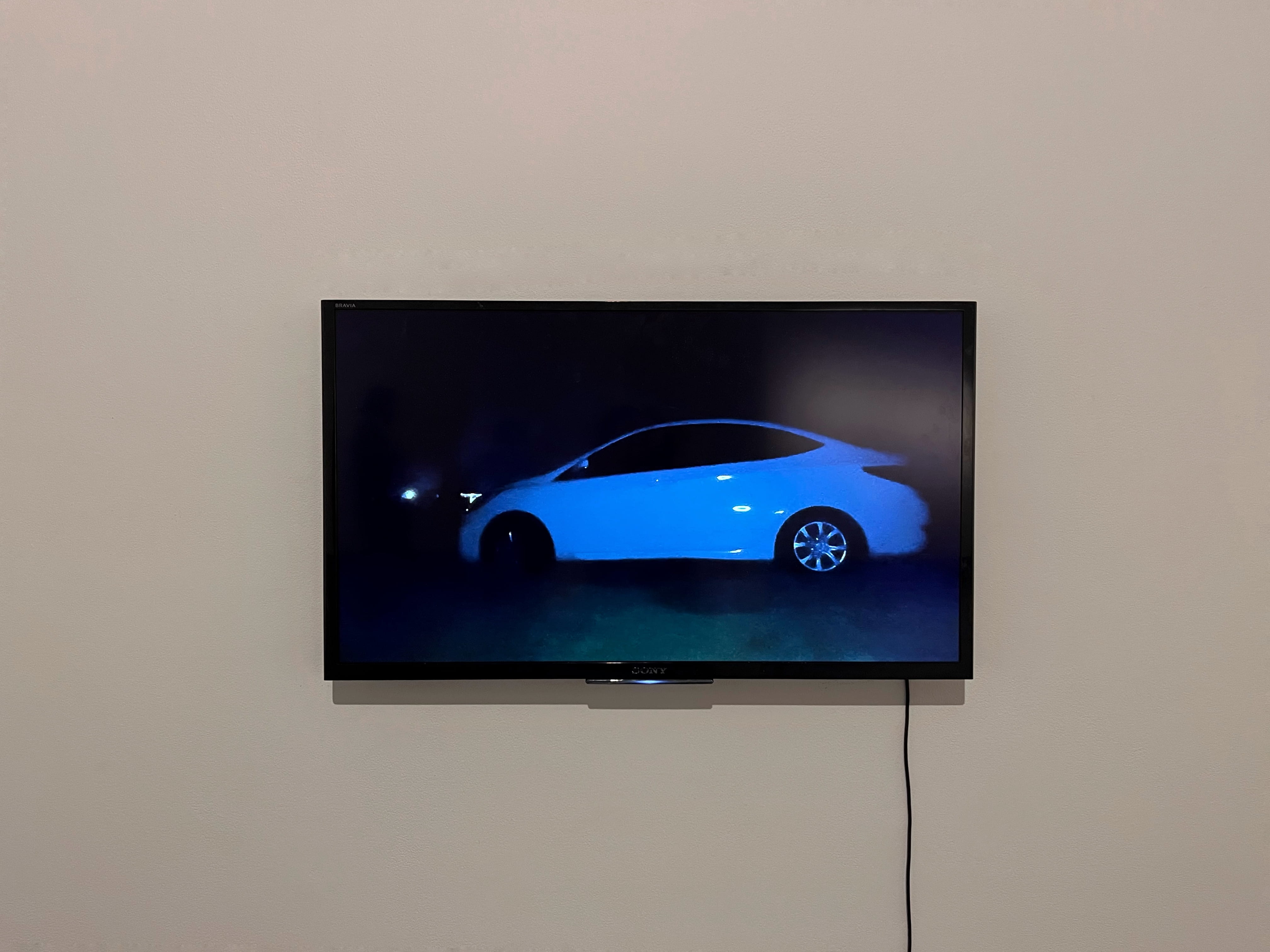 Still image of video work ‘Behind Closed Doors’ presented on wall mounted digital tv monitor.