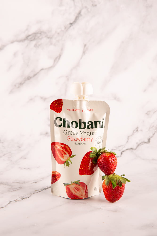 Chobani strawberry yogurt with a couple of strawberries