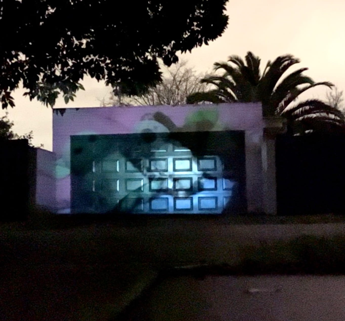 A photo of a bed is projected over a garage door.