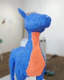 A blue and orange sculptured faun.
